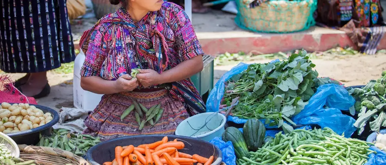 Mulher vende vegetais no mercado em Solola