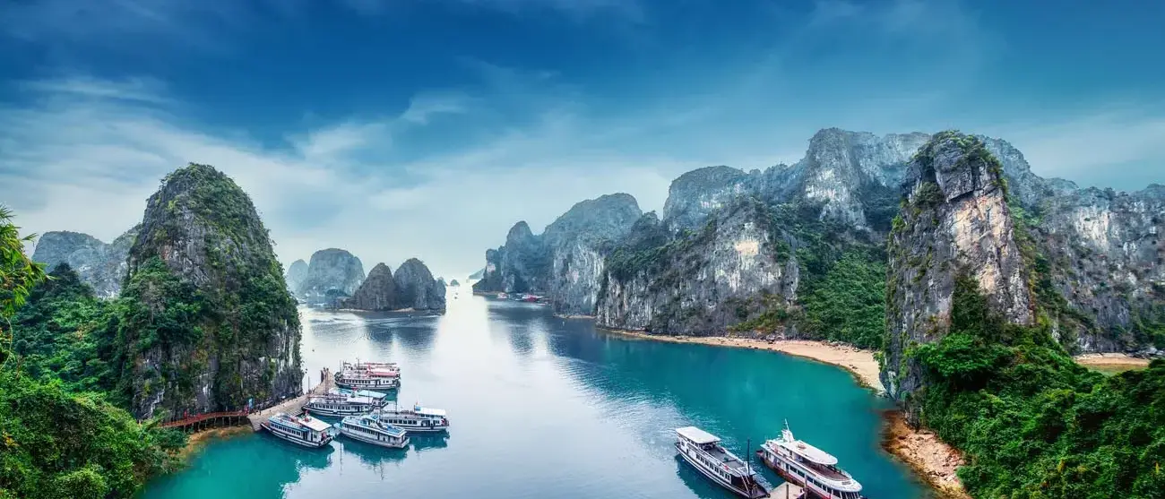 Barcos turisticos flutuando entre rochas calcárias em Ha Long Bay, Mar do Sul da China, Vietnã, sudeste da Ásia