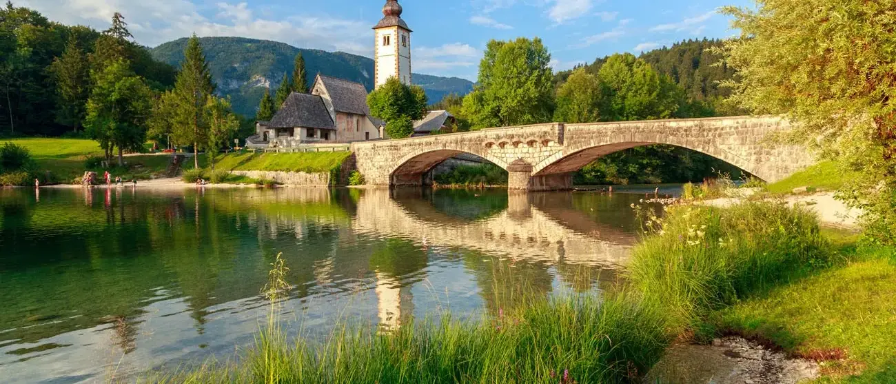 igreja-de-sv-joao-batista-e-uma-ponte-pelo-lago-bohinj-eslovenia
