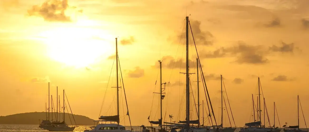 Moored sailboats in a St. Martin Harbor at sunset