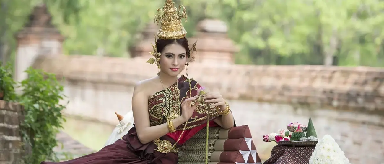 Mulher que desgasta o vestido thai típico com thai fundo do estilo do templo, cultura identidade de Tailândia