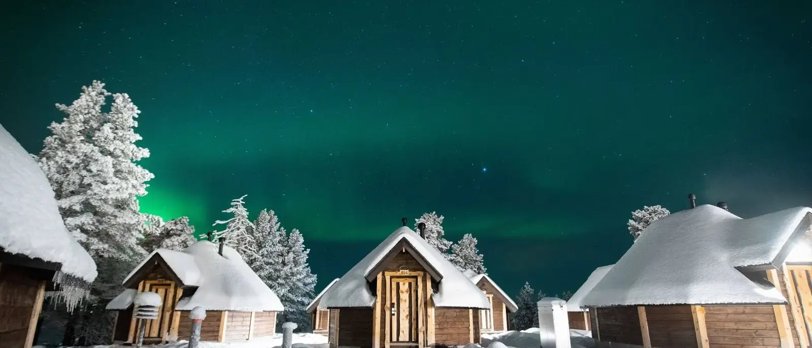 Cabines sob a Aurora Boreal em Saariselka